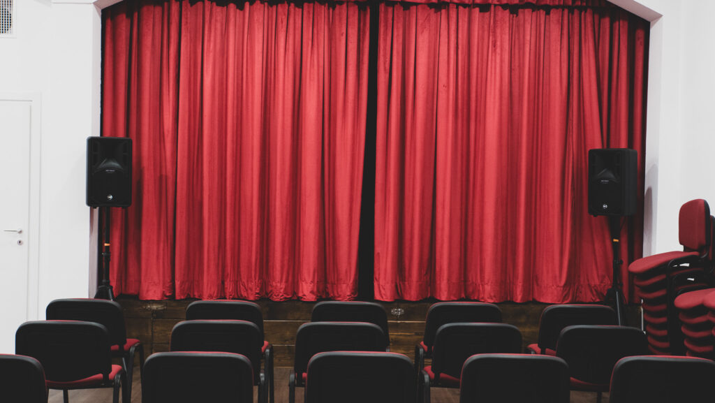 Il sipario e le sedie in velluto rosso del Teatro degli Audaci Off